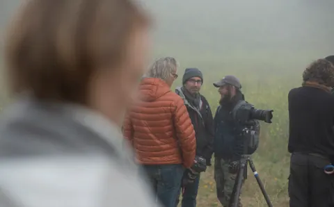 A camera crew gathering in a misty outdoor location.