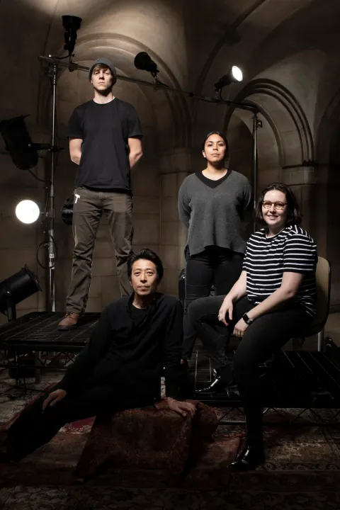 A group posing on steps in a stone interior.