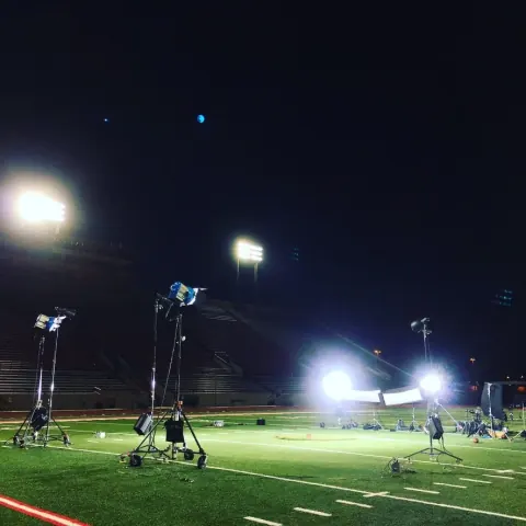 Lighting stands illuminating an outdoor sports field at night.