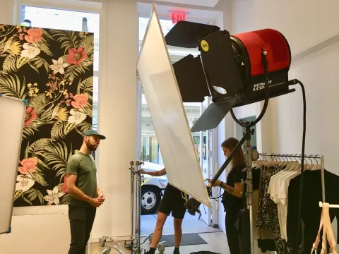 A large red studio lamp and diffusion panel beside a floral set.