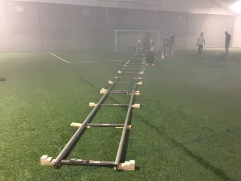 A long camera track crossing an indoor sports field.