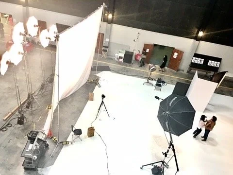 Overhead view of lighting panels and cameras on a white studio set.