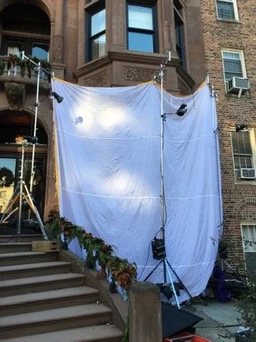 A white diffusion screen suspended outside a building above its front steps.