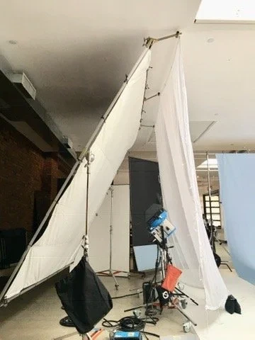 Large white reflector panels leaning together on a studio floor.