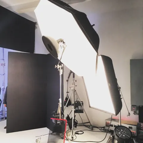 A close view of overlapping studio softboxes and light stands.