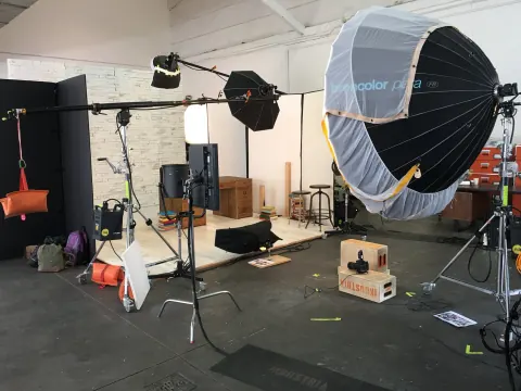 A large circular softbox and other lights on a studio floor.