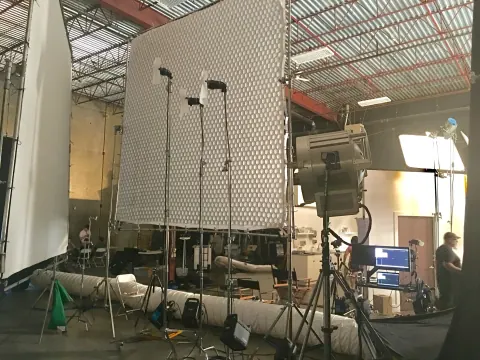 A large patterned diffusion panel and camera equipment inside a warehouse.