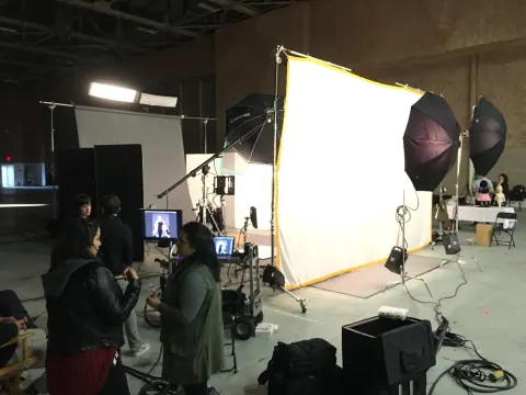 A crew working beside a large illuminated diffusion panel.