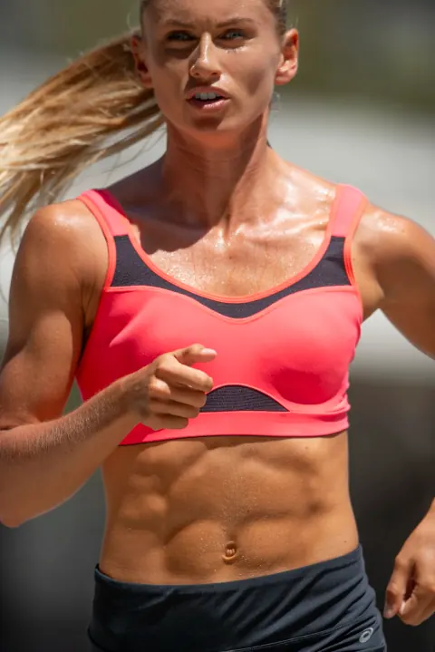 Close-up of a runner wearing a bright pink sports bra.