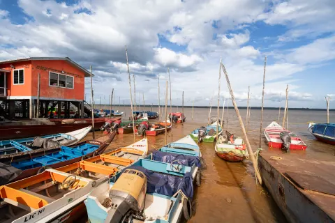 Colourful boats moored beside a riverside building.