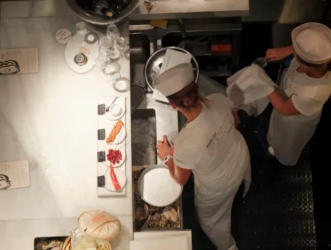 Overhead view of chefs working closely together in a restaurant kitchen.