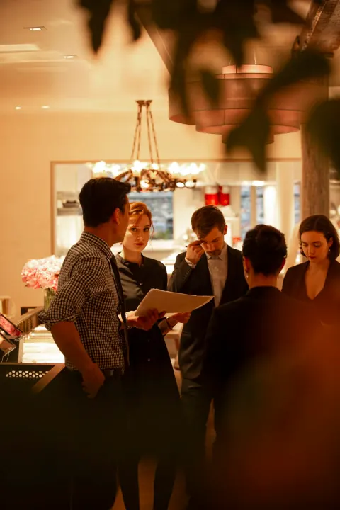 Diners and staff in a warmly lit restaurant.