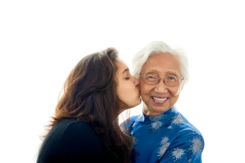A woman kissing another woman on the cheek as she smiles.