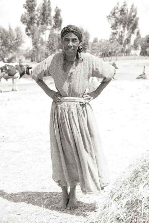 A black-and-white portrait of a woman standing with her hands on her hips.